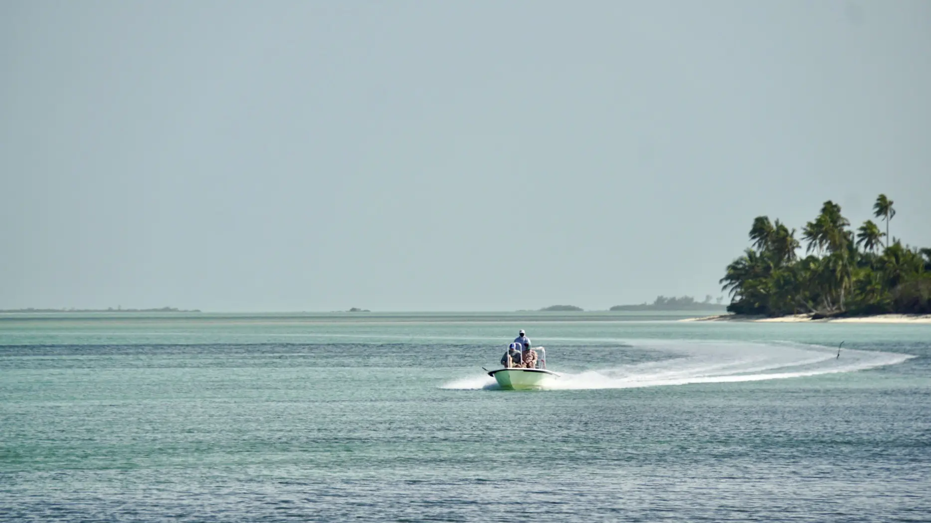 A flats skiff running out across the flats